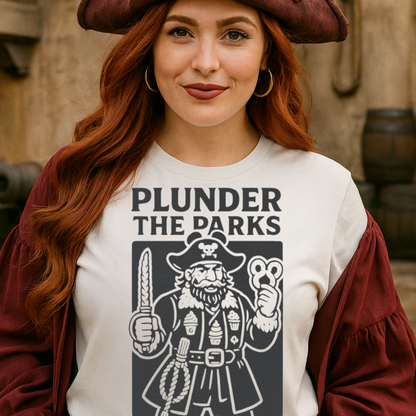 Person wearing a pirate-themed t-shirt with text and graphics, standing in a rustic setting.