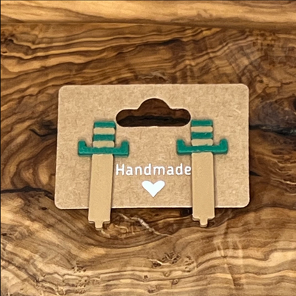 Pair of earrings on a 'Handmade' card against a wooden background