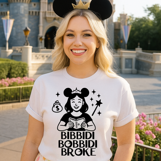 Woman wearing a white t-shirt with a graphic design and text, standing in front of a castle.