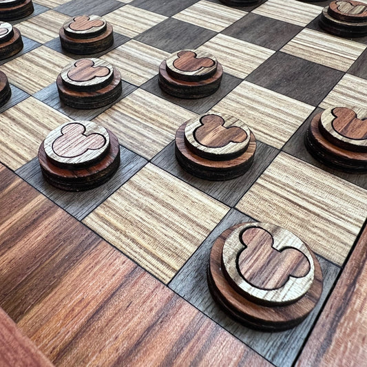 A close-up view of a handcrafted wooden checkerboard with beautifully contrasting natural wood grains, accompanied by matching wooden checker pieces.